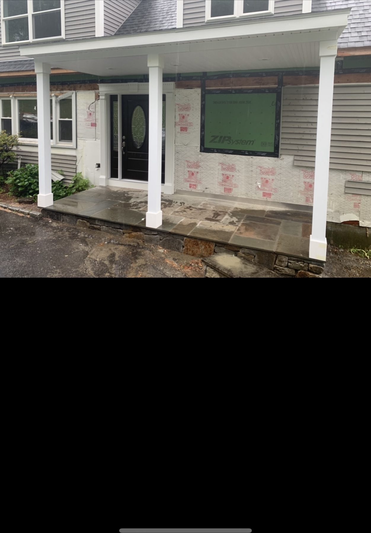 Before — front entry porch wrapped in green ZIP System sheathing during a siding and carpentry project