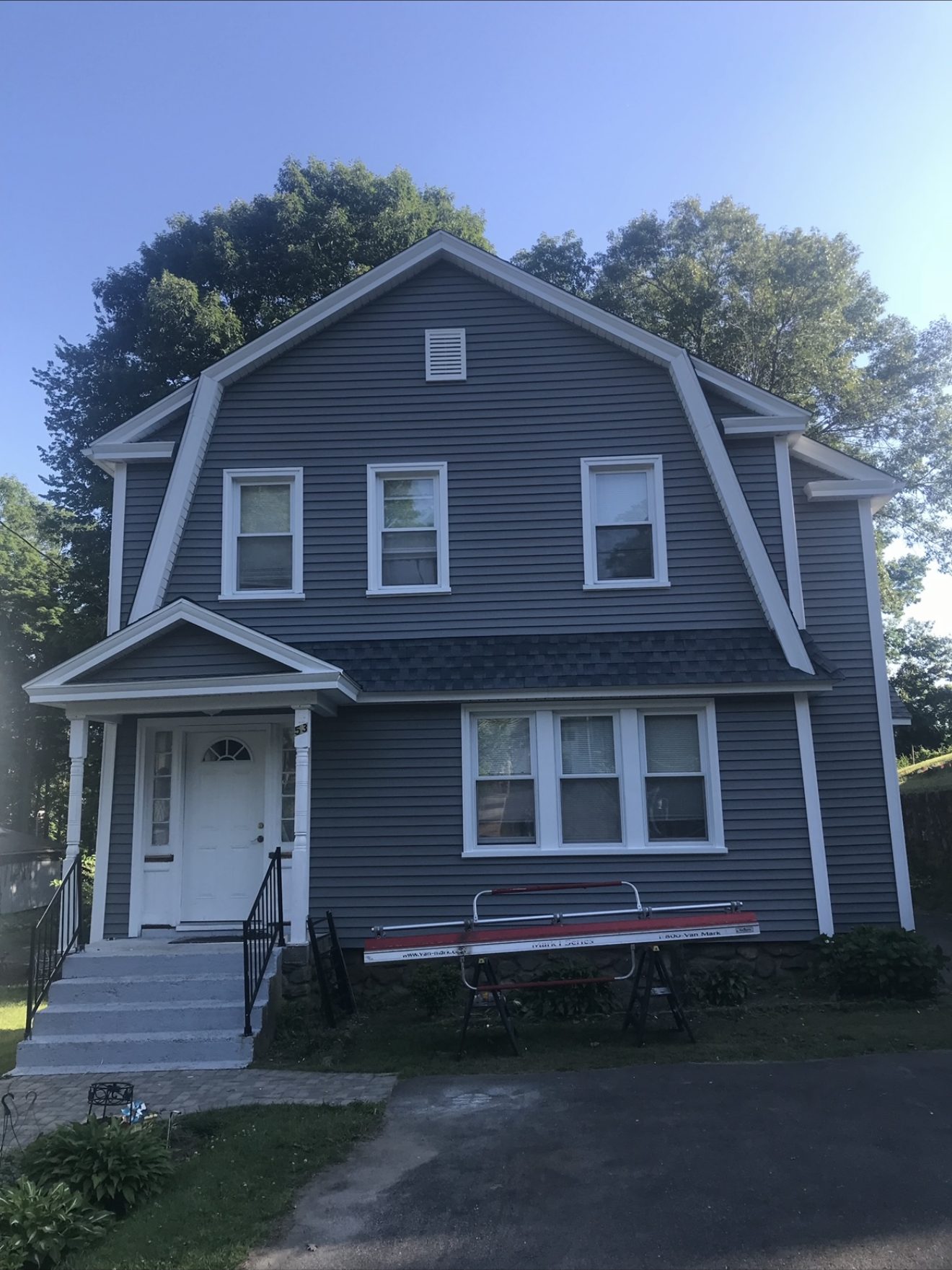 Finished Connecticut colonial home with new gray vinyl siding and crisp white trim
