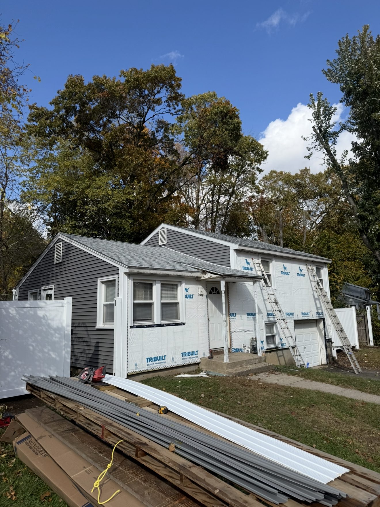Vinyl siding installation in progress on a ranch-style Connecticut home
