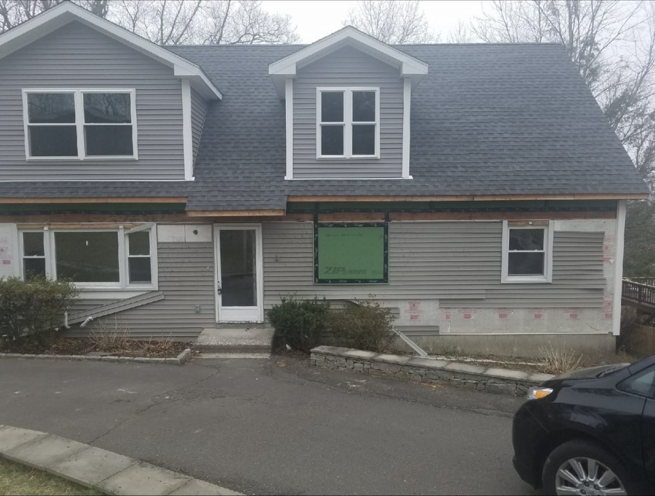 Finished Connecticut home with new gray siding, windows, and dormer trim