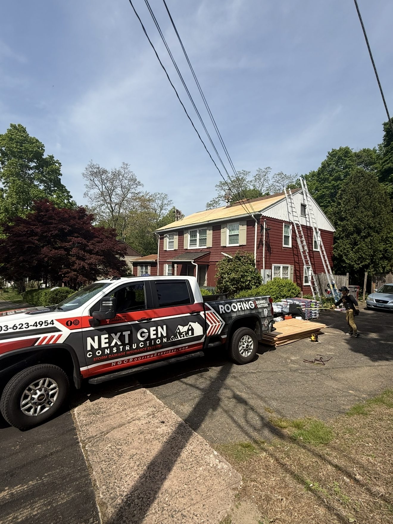 Next Gen Construction branded work truck parked at a Connecticut job site mid roof replacement